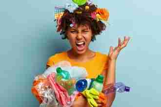 A girl holding lots of different trash looking for solid waste management