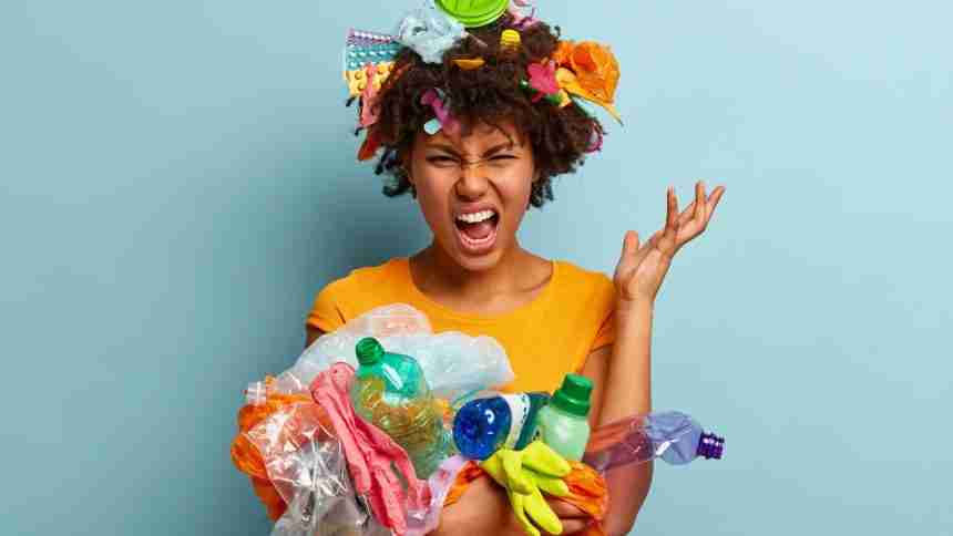 A girl holding lots of different trash looking for solid waste management